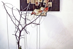 The Visit • Installation, Acrylic and Tar on Panel with Painted Canvases in Plexiglas, Faucet Valves with Painted Strings, Piece of a Civil War Era Quilt, Dead Tree and Reflecting Pool, 80 x 72 x 60 inches (variable tree size) (203.2 x 182.88 x 152.4 cm)